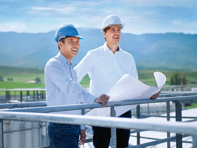To ingeniører står på toppen av en lagertank.