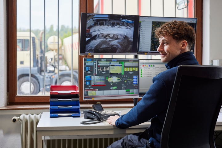 mann foran skjermer på kontor