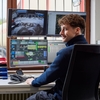 mann foran skjermer på kontor
