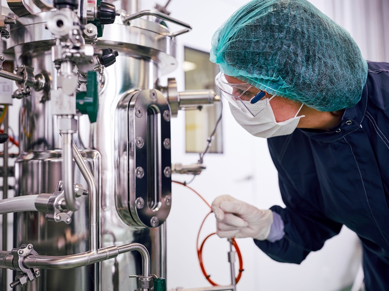 Forsker med en fermenteringsenhet for biofarmasøytisk produksjon i Life Science-industrien Fermenterer og forsker innen biofarmasøytisk produksjon