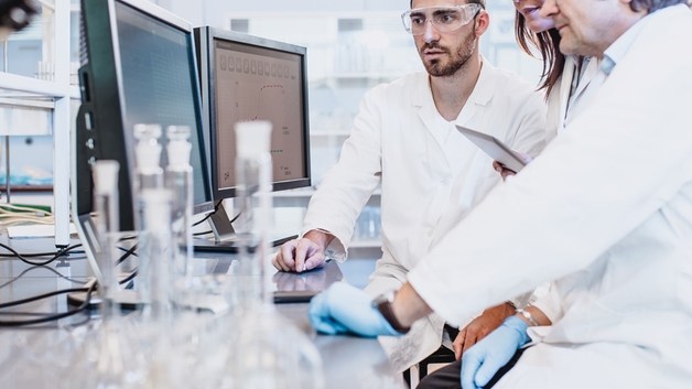 Forskere jobber i laboratoriet og ser på dataskjermen